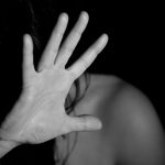 a black and white photo of a woman with her hand over her face.