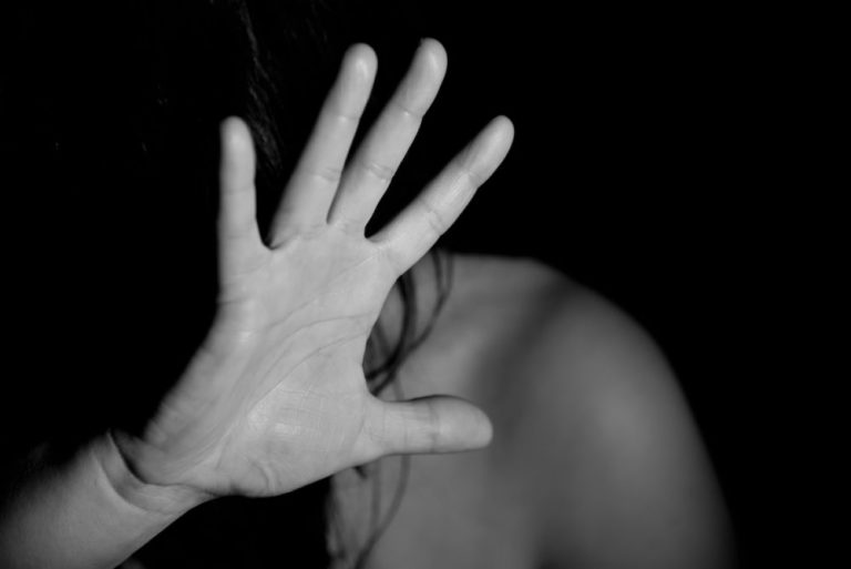 a black and white photo of a woman with her hand over her face.