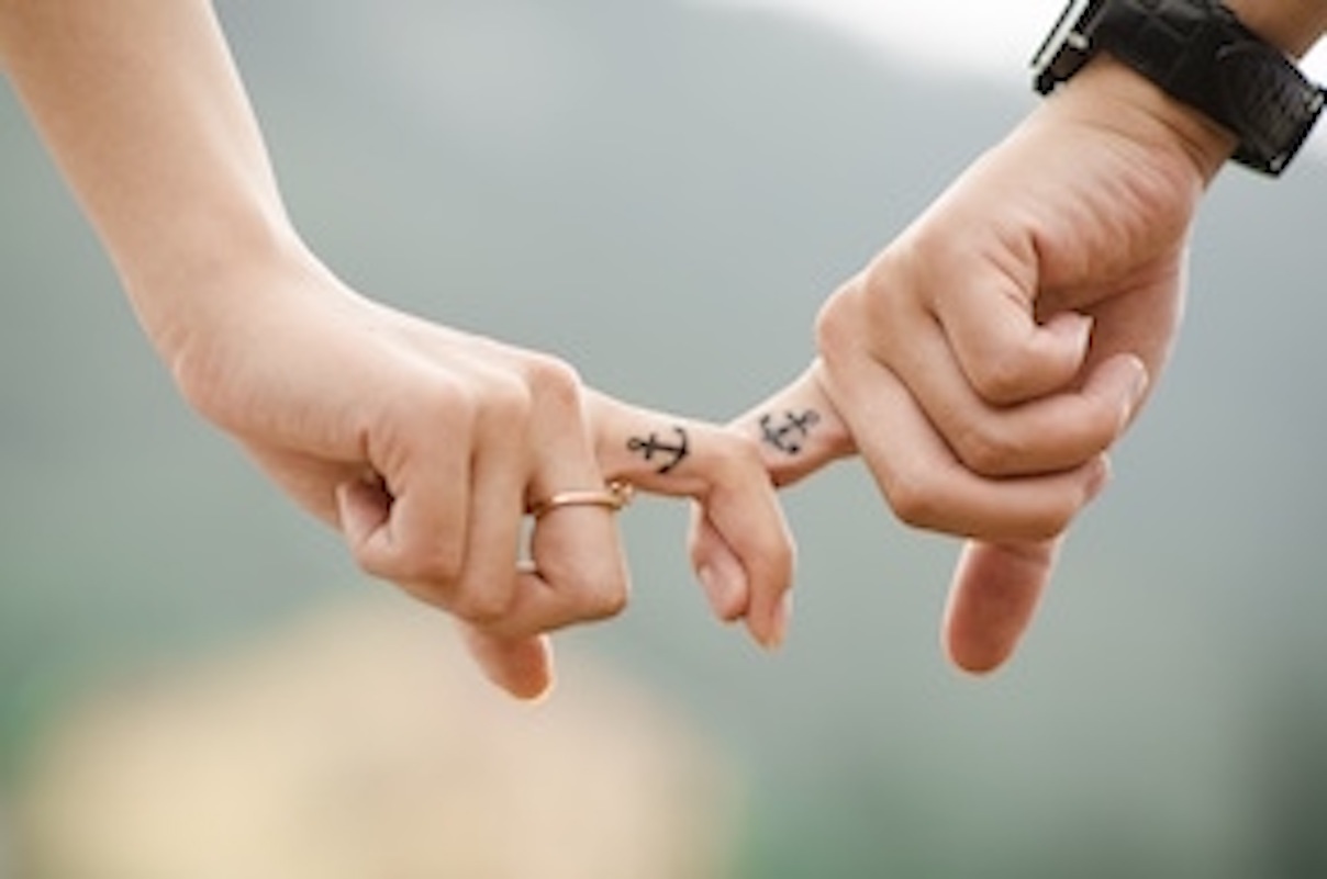 a close up of two people holding hands.