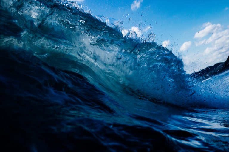 a large wave is breaking in the ocean.