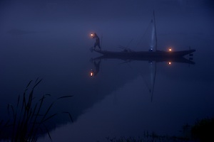 a boat floating on top of a lake at night.
