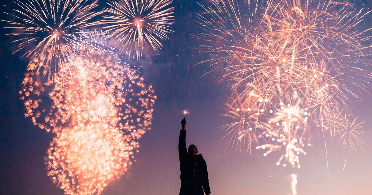 a person standing in front of a firework display.